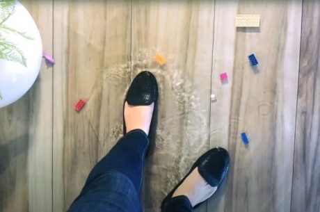 woman standing in puddle of watert in living room after a property damage emergency that caused water damage to her home in long island